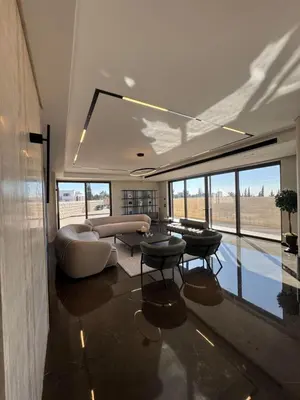 a living room with a couch and tables and windows at Dabouq Luxurious Penthouse in Amman