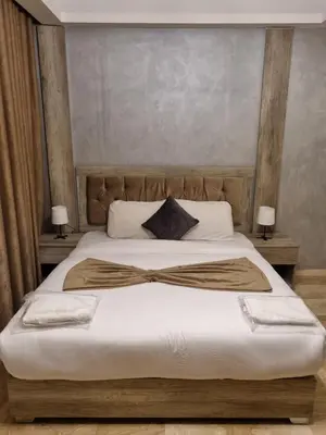 a bedroom with a large bed with a wooden headboard at unique 2bedroom at abdoun 001 in Amman