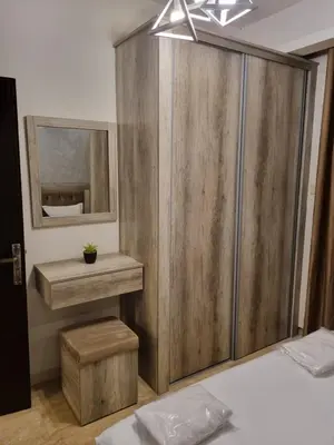 a bedroom with a wooden wardrobe and a mirror at unique 2bedroom at abdoun 001 in Amman