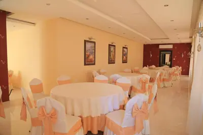 a banquet hall with white tables and chairs at Montana Residence in Amman