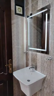 a bathroom with a white sink and a mirror at Al Wesam Furnished Apartments in Aqaba