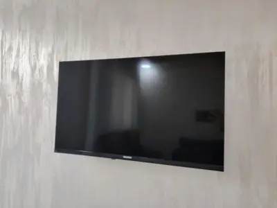 a flat screen tv hanging on a wall at Al Wesam Furnished Apartments in Aqaba