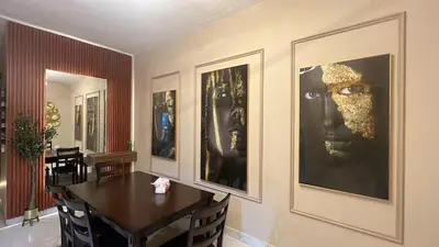 a dining room with a table and pictures on the wall at Art loft in Amman