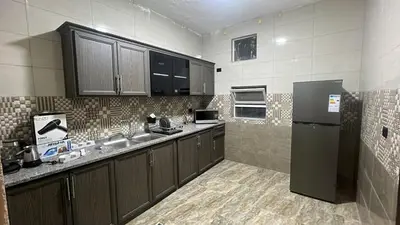 a kitchen with wooden cabinets and a refrigerator at Art loft in Amman