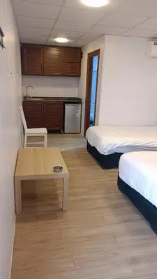 a room with two beds and a table and a kitchen at Rum Pillars Camp in Disah