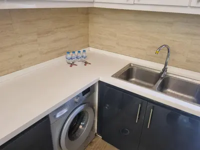 a kitchen counter with a sink and a washing machine at unique 2bedroom at abdoun 006 in Amman