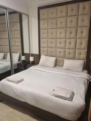 a bedroom with a large bed with a large headboard at unique 2bedroom at abdoun 006 in Amman