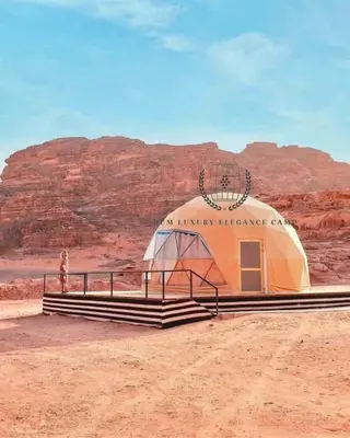 a tent in the desert with a mountain in the background at RUM ELEGANCE BUBBLE lUXURY CAMP in Wadi Rum