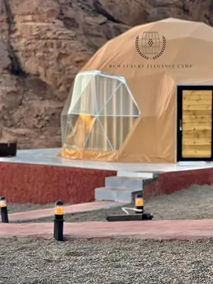 a dome tent with a table in front of a mountain at RUM ELEGANCE BUBBLE lUXURY CAMP in Wadi Rum