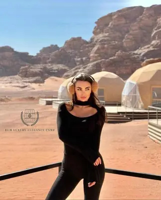 a woman in a black dress standing in the desert at RUM ELEGANCE BUBBLE lUXURY CAMP in Wadi Rum