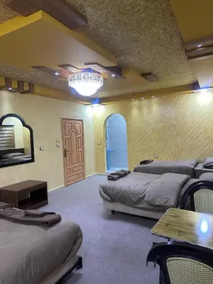 a room with beds and a table and a door at WaterMill House in Wadi Musa