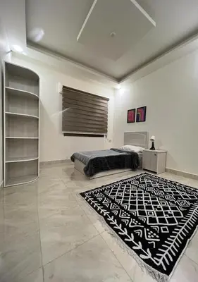 a bedroom with a bed and a black and white rug at Sweet Home In Amman - Family Friendly in Amman