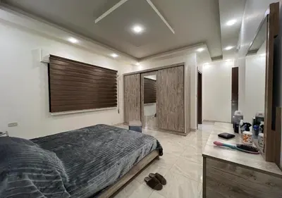 a bedroom with a large bed and a bathroom at Sweet Home In Amman - Family Friendly in Amman