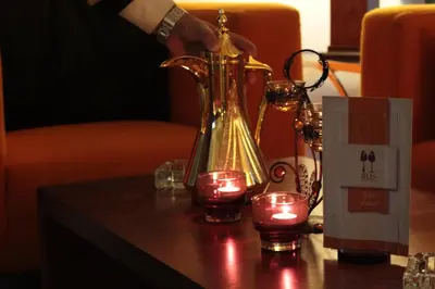 a table with a tea kettle and candles on it at Meneur Hotel in Amman