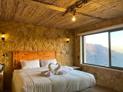 a bedroom with a large bed with a large window at Dana Trail Hotel in Dana