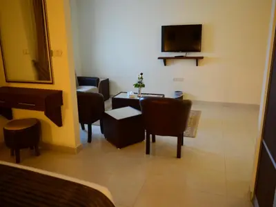 a living room with a couch and a television at Ream Hotel Amman in Amman