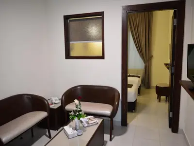 a hotel room with chairs and a table and a tv at Ream Hotel Amman in Amman