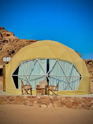 a dome tent with chairs and tables in the desert at RUM CAMILLA lUXURY CAMP in Wadi Rum