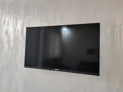a flat screen tv hanging on a wall at Al Wesam Furnished Apartments in Aqaba