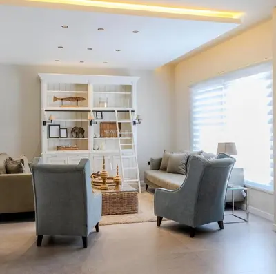 a living room with two chairs and a couch at Flamant Apartments in Amman