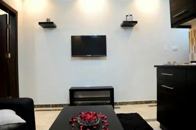 a living room with a table and a tv on a wall at سامر برهم للاسكان in Amman