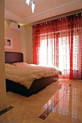 a bedroom with a bed and a window with red curtains at سامر برهم للاسكان in Amman
