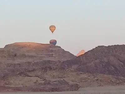 a hot air balloon flying over a mountain at Laurana Rum Luxury Camp in Wadi Rum
