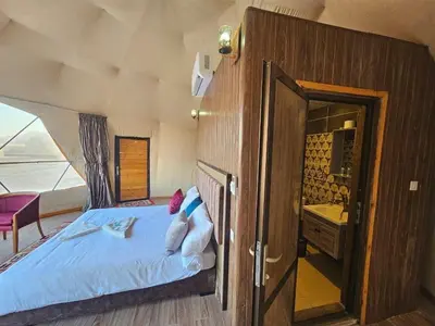 a bedroom with a bed and a bathroom with a mirror at Laurana Rum Luxury Camp in Wadi Rum