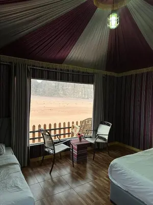 a bedroom with a bed and a view of a beach at Laurana Rum Luxury Camp in Wadi Rum