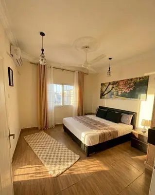 a bedroom with a large bed and a window at White Apartment in Aqaba