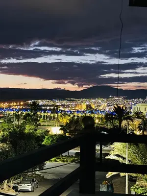 a view of a city from a balcony at night at White Apartment in Aqaba