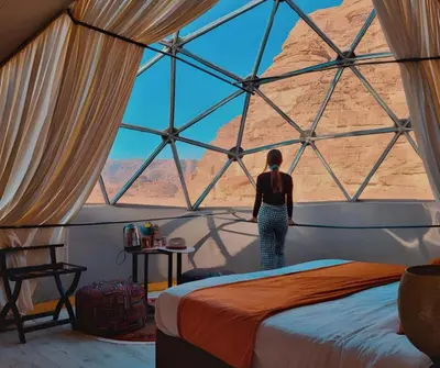 a woman standing in a room with a large window at Green Desert in Wadi Rum