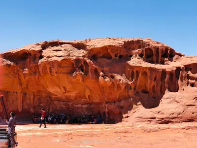 a group of people standing in front of a cliff at Rum Experience in Aqaba