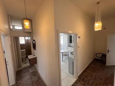a room with a hallway with a door and a kitchen at Locations Amman Palm Tree 4 in Ash Shumaysānī