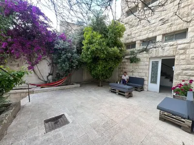 a person sitting on a bench in a courtyard at Locations Amman Palm Tree 4 in Ash Shumaysānī