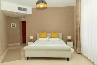 a bedroom with a large bed with yellow pillows at High-end Apartment 2BDR in The most lively AMMAN شقة فاخرة في الدوار السابع in Amman