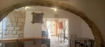 an archway in a living room with a table and chairs at Dana Moon hostel in Dana