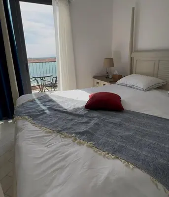 a bedroom with a bed with a red pillow on it at Azure haven Ayla Sea view Apartment in Aqaba