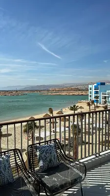 a bench sitting on a balcony overlooking the beach at Azure haven Ayla Sea view Apartment in Aqaba