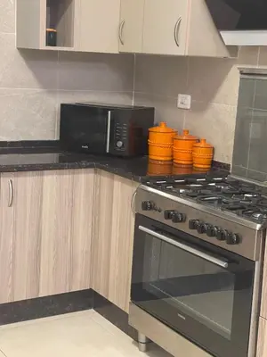 a kitchen with a stove and a microwave at Family Spacious newly furnished 2 Bedroom 2 bath in Amman