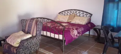 a bed and a chair in a room at Offgrid Jerash-Ajlune MountainView Studio Shalea شاليه استوديو جبال جرش in Jerash