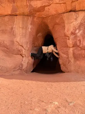 a person is standing in a tunnel in a rock at Wadi Rum party luxury camp in Disah