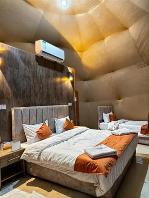 two beds in a room with a ceiling at Wadi Rum party luxury camp in Disah