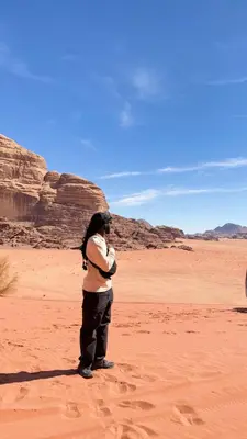a person standing in the desert at Wadi Rum party luxury camp in Disah
