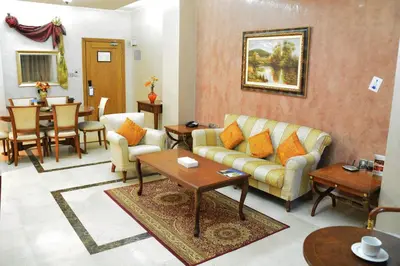 a living room with a couch and a table at فندق أميري سويت in Umm Uthainah