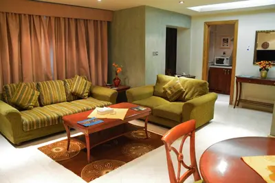 a living room with a couch and a table at فندق أميري سويت in Umm Uthainah