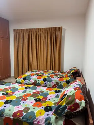 a bed with a flowered comforter in a bedroom at Abdoun apartment with a garden in Amman