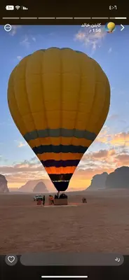 a hot air balloon on a beach with people and dogs at Sami Rum Mountains in Wadi Rum