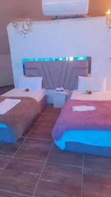 a bedroom with two beds and a tile floor at Sami Rum Mountains in Wadi Rum