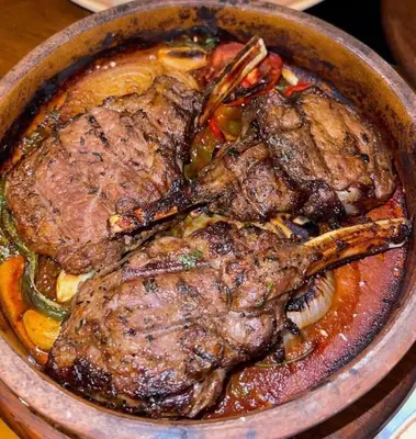 a bowl of food with two pieces of meat at Daban Inn in Dhībān